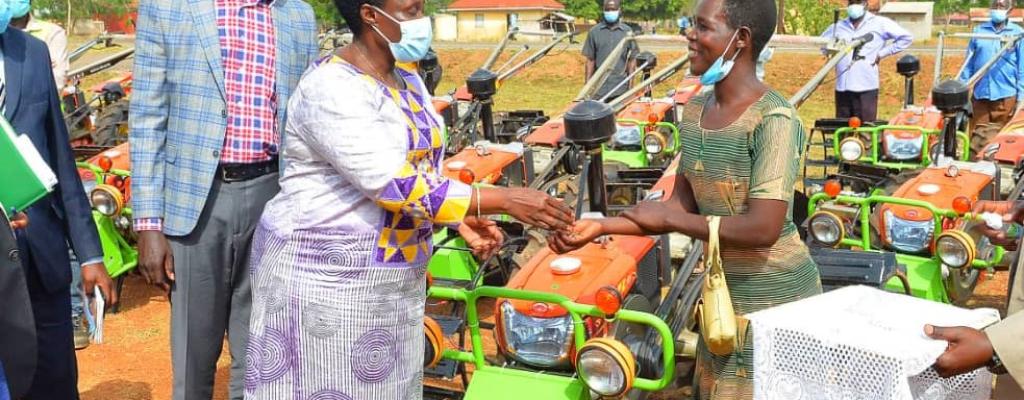 Stella Aleo receiving  a walking Tractor from the vice president - Jesca Alupo Epel